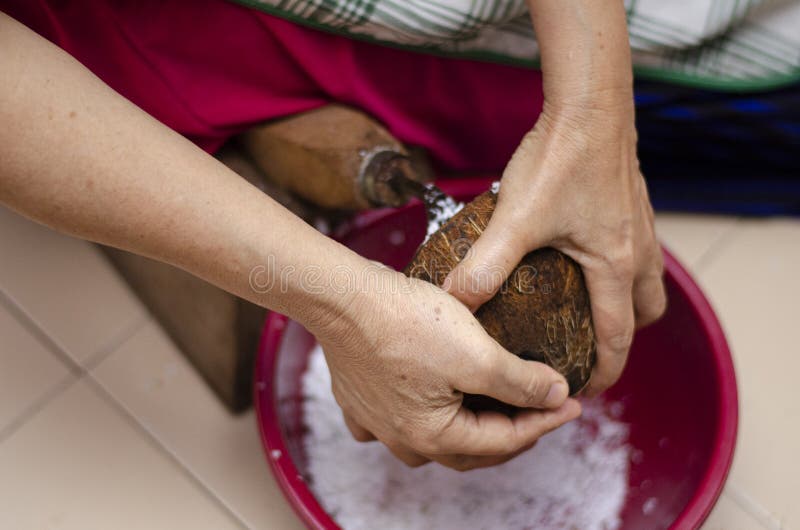 Close up of man hand grated coconut using an electric coconut grater in  Thailand Stock Photo