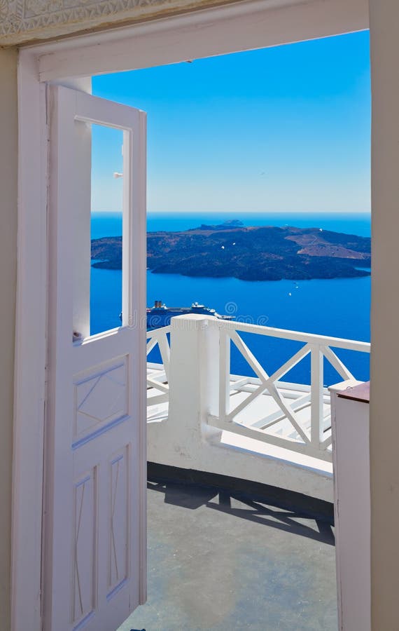 Traditional white door on Santorini Island, Greece, with view over volcanic caldera and cruise ship