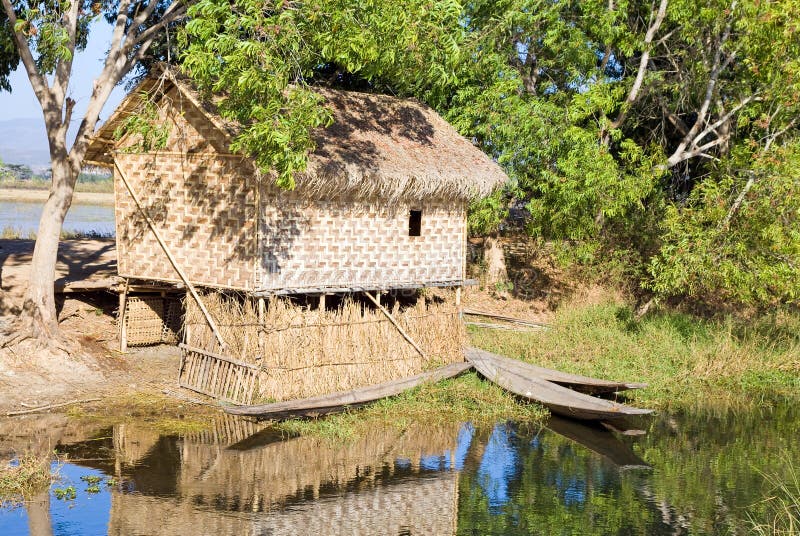 Traditional wooden stilt house and canoe stock images