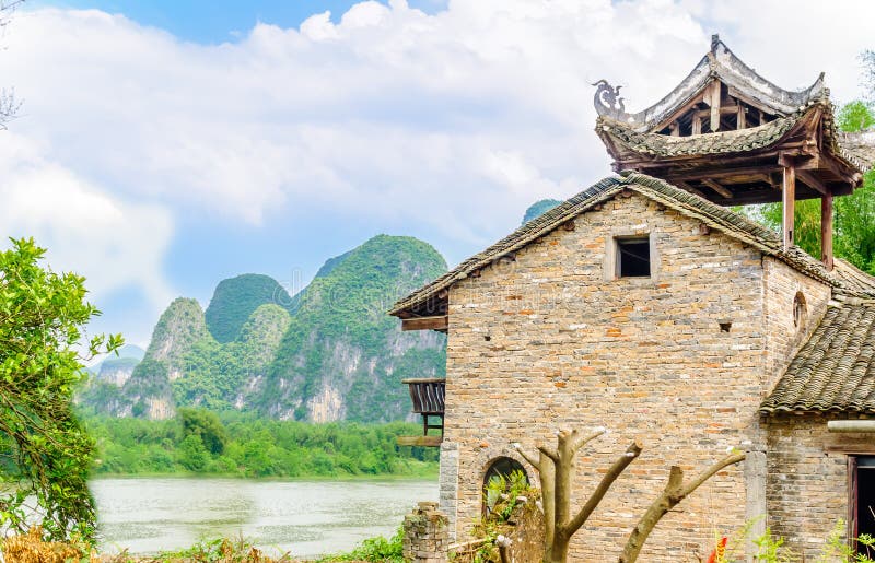 Traditioneel ruggegratenhuis in karst landschap door Yangshuo - China royalty-vrije stock afbeeldingen Traditioneel ruggegratenhuis in karst landschap door Yangshuo - China royalty-vrije stock afbeeldingen