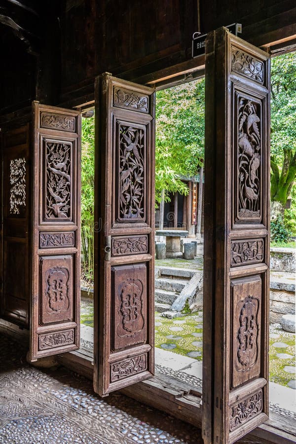 Traditionele Chinese houten gesneden die deuren op een binnenplaats worden geopend stock foto's Traditionele Chinese houten gesneden die deuren op een binnenplaats worden geopend stock foto's