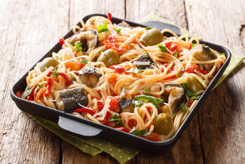 Traditionele deegwarenschotel met geroosterde paling, olijven, peper en tomatensausclose-up op een plaat horizontaal royalty-vrije stock fotografie Traditionele deegwarenschotel met geroosterde paling, olijven, peper en tomatensausclose-up op een plaat horizontaal royalty-vrije stock fotografie