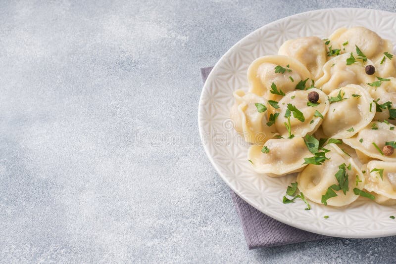 Traditional pelmeni, ravioli, dumplings filled with meat on plate, russian kitchen. Copy space. Traditional pelmeni, ravioli, dumplings filled with meat on plate, russian kitchen. Copy space