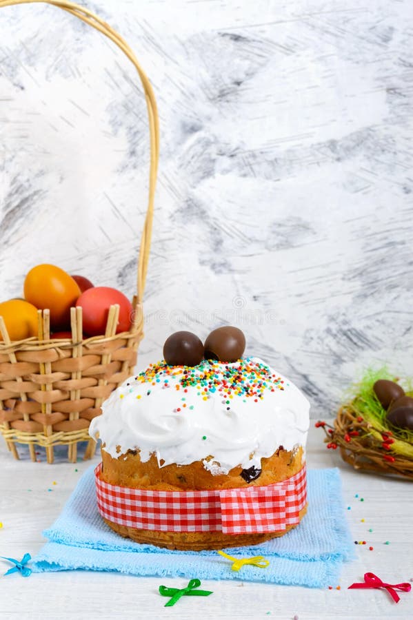 Traditionele Pasen-cake - kulich, chocoladeeieren in een nest, en kleurrijke geschilderde eieren op een houten witte achtergrond royalty-vrije stock foto's Traditionele Pasen-cake - kulich, chocoladeeieren in een nest, en kleurrijke geschilderde eieren op een houten witte achtergrond royalty-vrije stock foto's