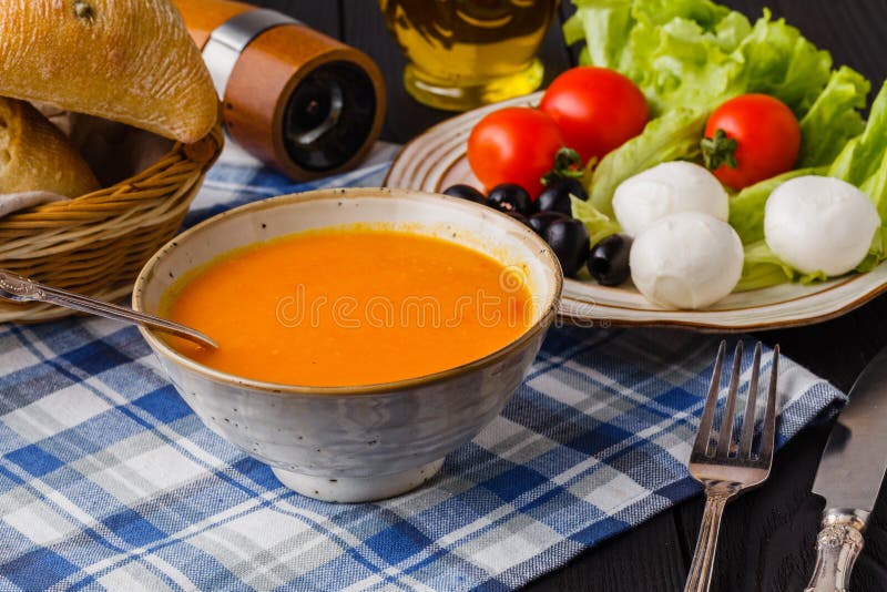 Traditionele verwarmende pompoensoep, eigengemaakt met brood en antipasti stock afbeelding Traditionele verwarmende pompoensoep, eigengemaakt met brood en antipasti stock afbeelding