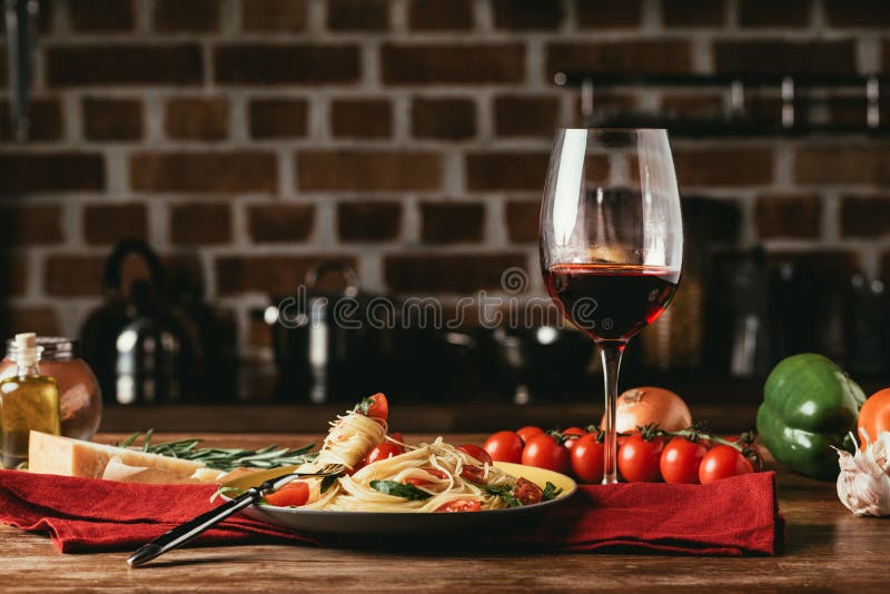 traditionell italiensk pasta med tomater och arugula i platta och exponeringsglas av royaltyfri foto traditionell italiensk pasta med tomater och arugula i platta och exponeringsglas av royaltyfri foto