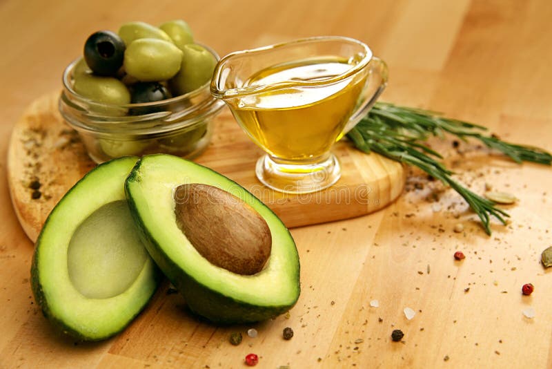 Food Ingredients. Olive Oil With Olives And Avocado On Table. Close Up Of Oil In Glass And Fresh Organic Vegetables, Healthy Products Lying On Wooden Table. Healthy Fats And Vitamins. High Quality. Food Ingredients. Olive Oil With Olives And Avocado On Table. Close Up Of Oil In Glass And Fresh Organic Vegetables, Healthy Products Lying On Wooden Table. Healthy Fats And Vitamins. High Quality