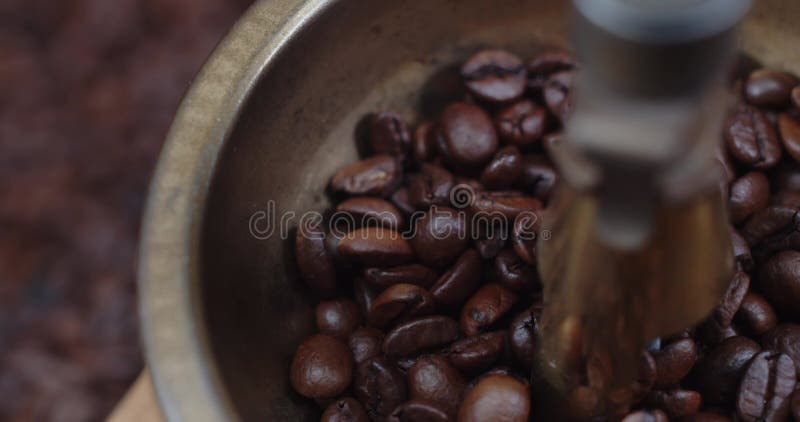 Traditionell manuell kaffekvarn. trä och koppar. kaffebönor kanelkryddor i mörk bakgrund. kamera