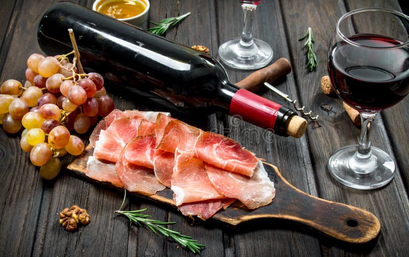Traditionell spansk skinka med druvor och rött vin fotografering för bildbyråer Traditionell spansk skinka med druvor och rött vin fotografering för bildbyråer