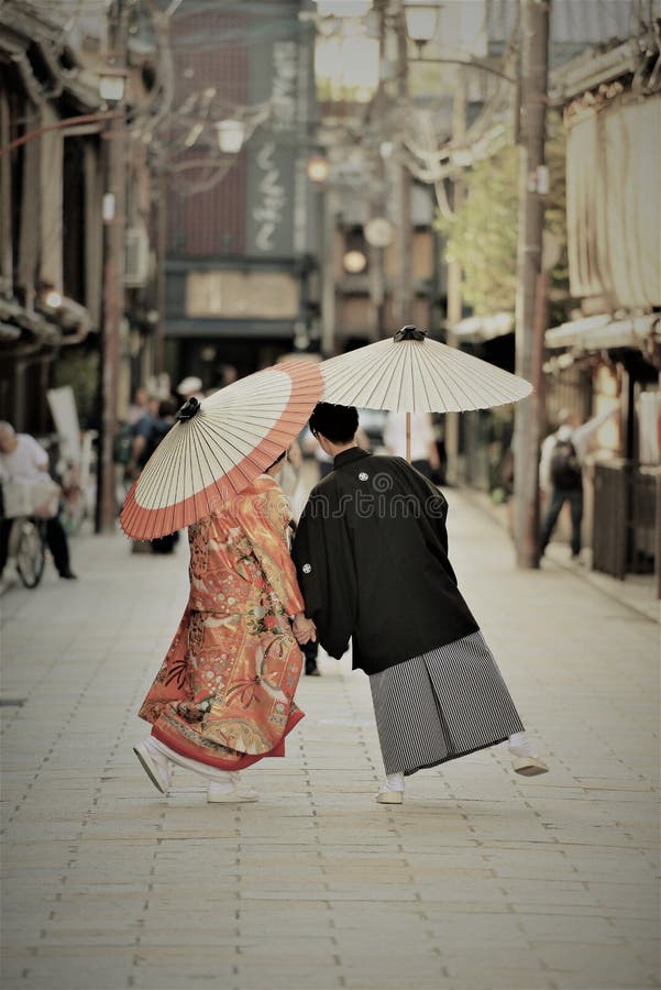 Traditionella japanska dräkter som är slitna vid ett ungt par på deras förbindelsedag royaltyfria bilder Traditionella japanska dräkter som är slitna vid ett ungt par på deras förbindelsedag royaltyfria bilder