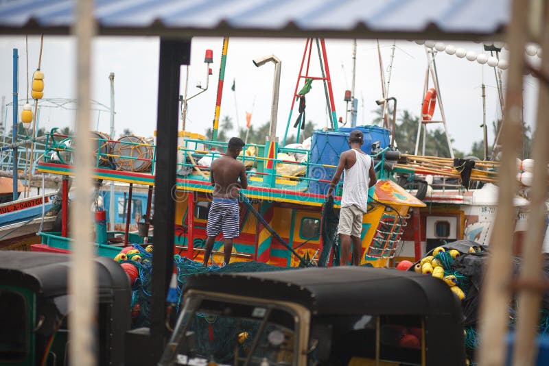 Traditionella Sri Lanka fiskebåtar i den Mirissa hamnen Fiskare river upp fisknät royaltyfri bild Traditionella Sri Lanka fiskebåtar i den Mirissa hamnen Fiskare river upp fisknät royaltyfri bild