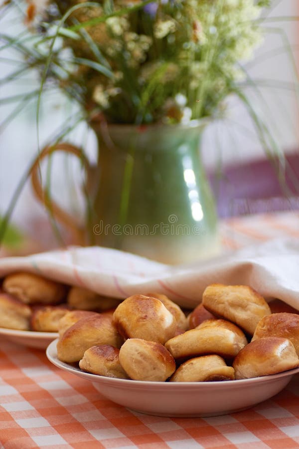 Traditional latvian bacon pies and meadow herbs background. Rustic style. Traditional latvian bacon pies and meadow herbs background. Rustic style.