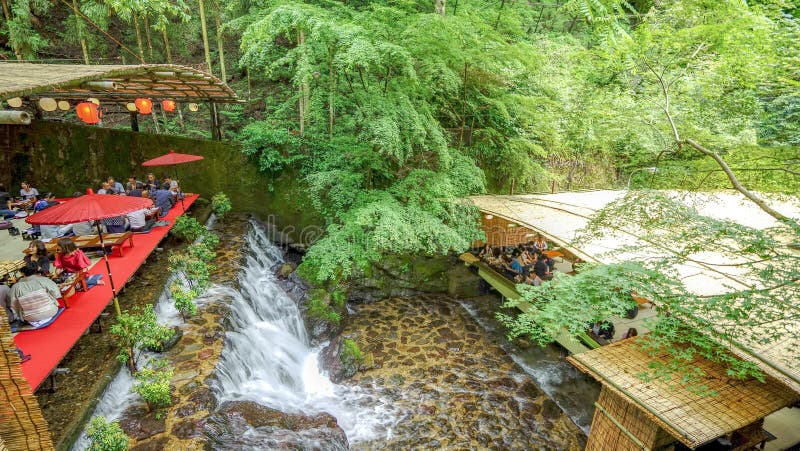 Traditionelles japanisches Restaurant mit natürlichem Wasserfall und grünem Baum stockbild