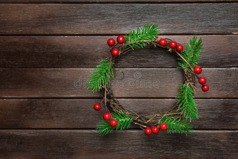 Traditionellt handgjort ris Holly Berries för filialer för träd för gran för julkransgräsplan på mörk plankaträbakgrund Top beskå arkivfoton Traditionellt handgjort ris Holly Berries för filialer för träd för gran för julkransgräsplan på mörk plankaträbakgrund Top beskå arkivfoton