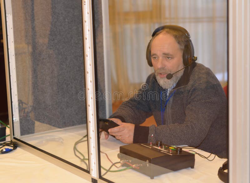 Translator at work. Sitting in a booth in headphones with a microphone. Translator at work. Sitting in a booth in headphones with a microphone.