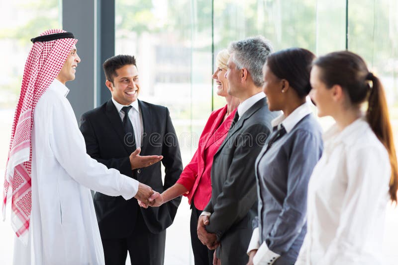 Young translator introducing Arabian businessman to business partners. Young translator introducing Arabian businessman to business partners