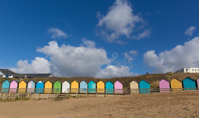 Tradycyjna colourful Angielska nadmorski scena z plażowymi budami na niebieskim niebie z pastelowymi colours i plaży obraz stock Tradycyjna colourful Angielska nadmorski scena z plażowymi budami na niebieskim niebie z pastelowymi colours i plaży obraz stock