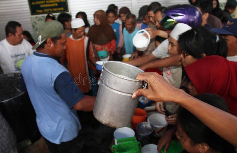 Locals line up to receive free traditional Samin porridge to break their fast. Solo, Indonesia. Locals line up to receive free traditional Samin porridge to break their fast. Solo, Indonesia