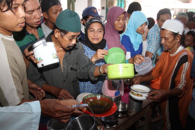 Locals line up to receive free traditional Samin porridge to break their fast. Solo, Indonesia. Locals line up to receive free traditional Samin porridge to break their fast. Solo, Indonesia