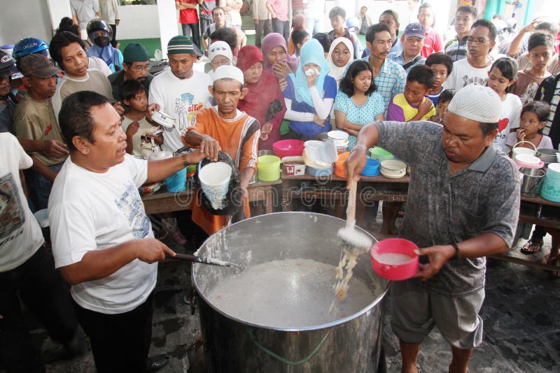 Locals line up to receive free traditional Samin porridge to break their fast. Solo, Indonesia. Locals line up to receive free traditional Samin porridge to break their fast. Solo, Indonesia