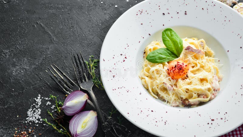 Tradycyjne włoskie danie z makaronu, spaghetti carbonara z żółtkiem, ser parmezan na płytce