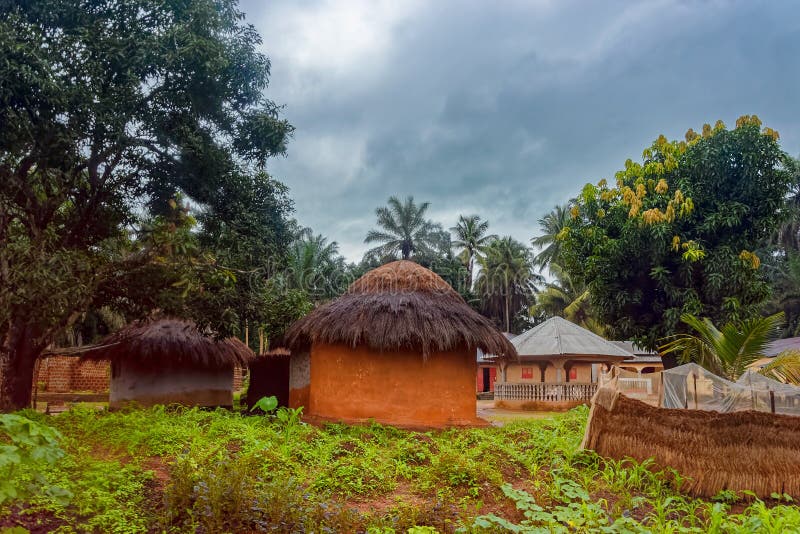 KAMSAR, GUINEA - August 10, 2018: Traditional thatched round mud and clay huts in rural village on the outskirts of the city of Kamsar. KAMSAR, GUINEA - August 10, 2018: Traditional thatched round mud and clay huts in rural village on the outskirts of the city of Kamsar