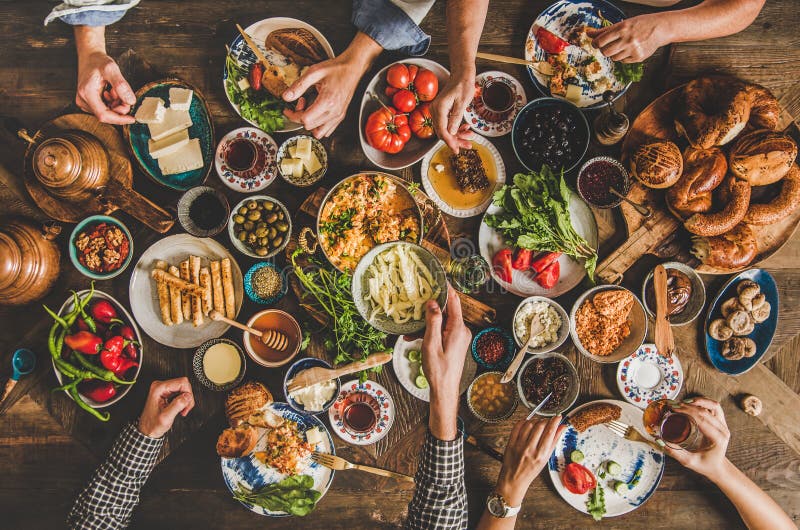Tradycyjny turecki stolik ze śniadaniem dla rodziny i ludzie spożywający różne potrawy