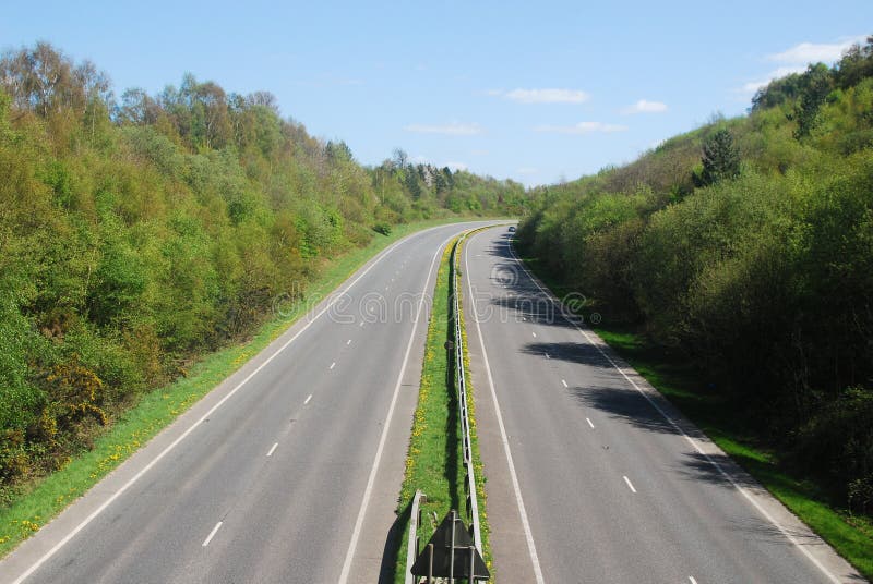 Traffic free dual carriageway road. A traffic free, tree lined dual carriageway seen in bright sunlight under a blue sky royalty free stock image Traffic free dual carriageway road. A traffic free, tree lined dual carriageway seen in bright sunlight under a blue sky royalty free stock image