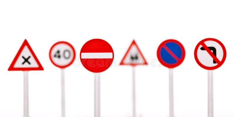 Collection of traffic signs in a row, isolated on white background with shallow DoF