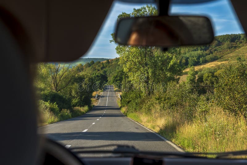 Traffic in the sun viewed from a car as blurred image with a long road forward stock image