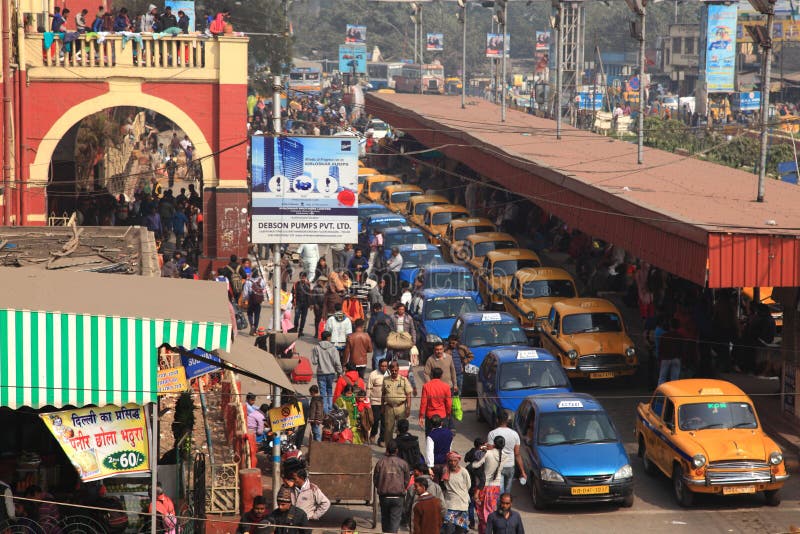 Traffico di veicolo e della gente vicino alla stazione ferroviaria nei precedenti del ponte di Howrah immagine stock Traffico di veicolo e della gente vicino alla stazione ferroviaria nei precedenti del ponte di Howrah immagine stock