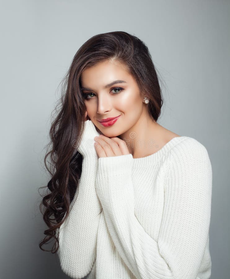 Tragende weiße Strickjacke der hübschen Frau Perfektes weibliches Modell mit dem langen gelockten Haar und Make-up lizenzfreie stockfotografie