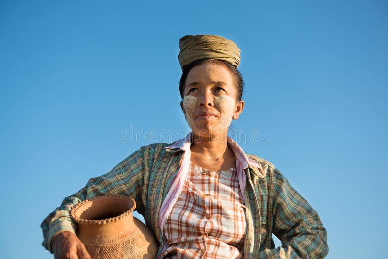 Tragendes Tongefäß des reifen asiatischen traditionellen weiblichen Landwirts stockbilder Tragendes Tongefäß des reifen asiatischen traditionellen weiblichen Landwirts stockbilder
