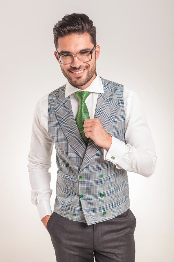 Tragendes weißes Hemd des Geschäftsmannes, graue Weste und grüne Bindung stockfoto