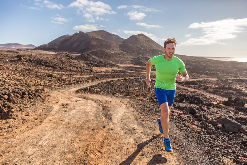 Trail runner male athlete running in nature rocky volcanic mountain background. Active fit sports man in compression sportswear