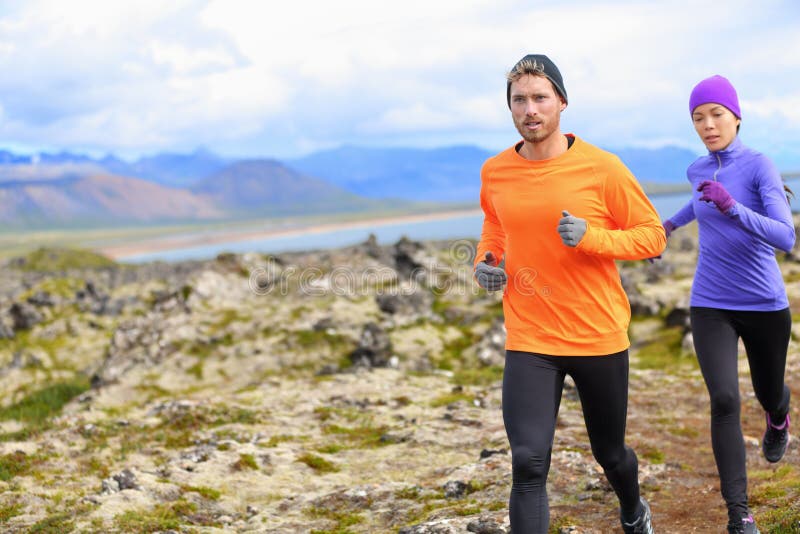 Trail runner men and women running cross-country run training outside for marathon. Jogging male athlete working out as part of healthy lifestyle. Image from Snaefellsnes, Iceland. Trail runner men and women running cross-country run training outside for marathon. Jogging male athlete working out as part of healthy lifestyle. Image from Snaefellsnes, Iceland.