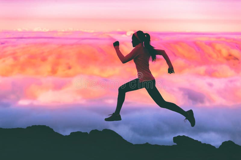 Trail running woman athlete runner exercising in mountains landscape background at sunset with pink color sky clouds