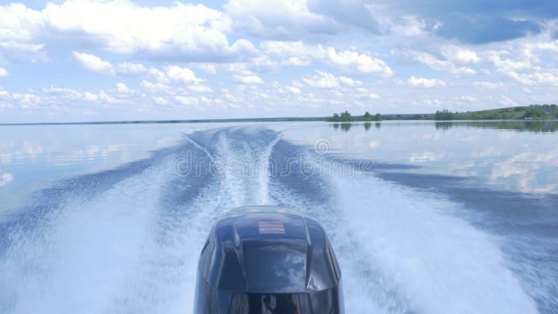 Trail on water surface behind of fast moving motor boat. the motor of motor boat, back view. Sea water ship trail with