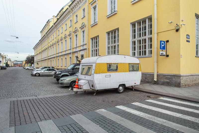 Trailer di colore giallo bianco parcheggiata per strada. strade deserte nel centro della città, primo giorno di autoisolamento immagini stock libere da diritti