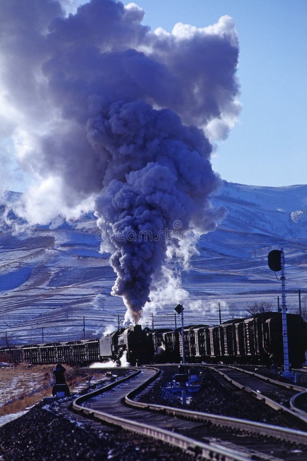 Steam train on station with a background of snowy mountain. Steam train on station with a background of snowy mountain