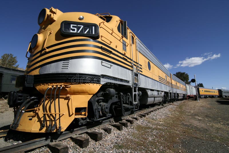 A beautiful yellow train stretches out along the railroad tracks. A beautiful yellow train stretches out along the railroad tracks.