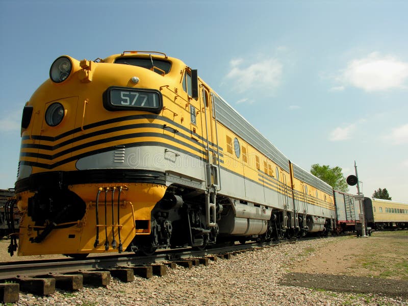 A beautiful yellow train stretches down the tracks. A beautiful yellow train stretches down the tracks