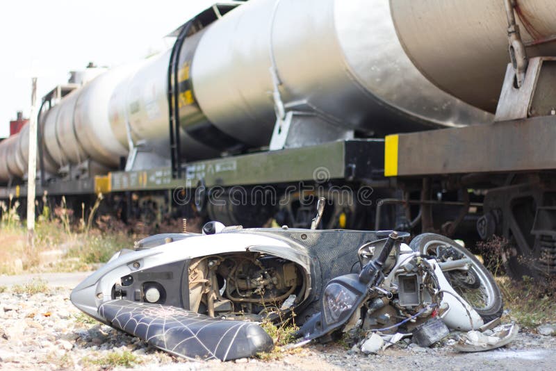 Close motorcycle overturned demolished lying on the ground near the fuel rails. Close motorcycle overturned demolished lying on the ground near the fuel rails.