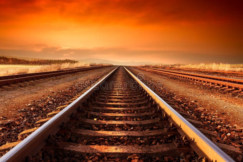 Train tracks goes to horizon in the majestic sunset.