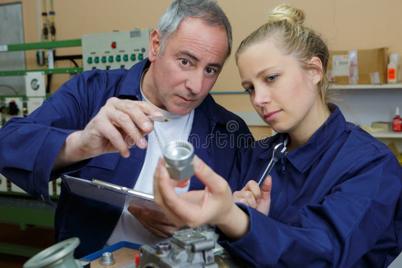 Trainee engineer showing component to supervisor royalty free stock images