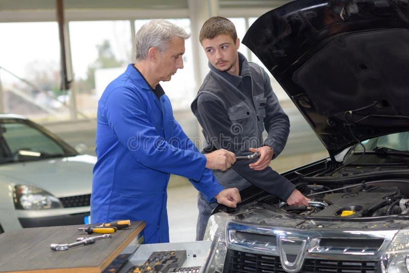 Trainee mechanic at work stock photo. Image of trainer 132188870