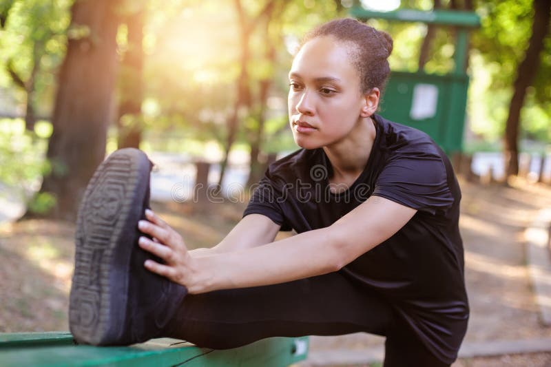 Training outdoors. Fit young woman stretching her legs. stock image Training outdoors. Fit young woman stretching her legs. stock image