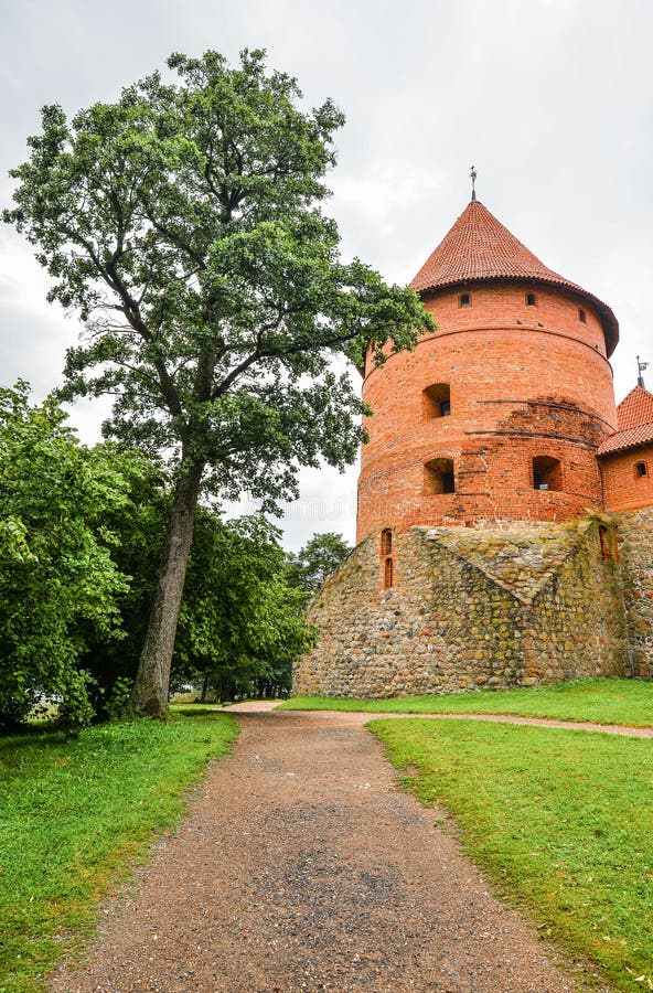 Trakai, Lituania - 15 de agosto de 2017: Paisaje hermoso del castillo antiguo de la isla de Trakai con el camino y el árbol, Litu fotos de archivo Trakai, Lituania - 15 de agosto de 2017: Paisaje hermoso del castillo antiguo de la isla de Trakai con el camino y el árbol, Litu fotos de archivo