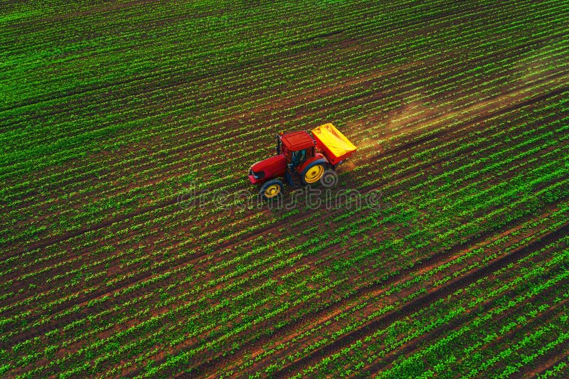 Traktor som odlar f?ltet p? v?ren, flyg- solnedg?ngsikt arkivfoton Traktor som odlar f?ltet p? v?ren, flyg- solnedg?ngsikt arkivfoton