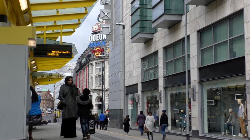 Tram aspettante della famiglia asiatica nel centro di Manchester